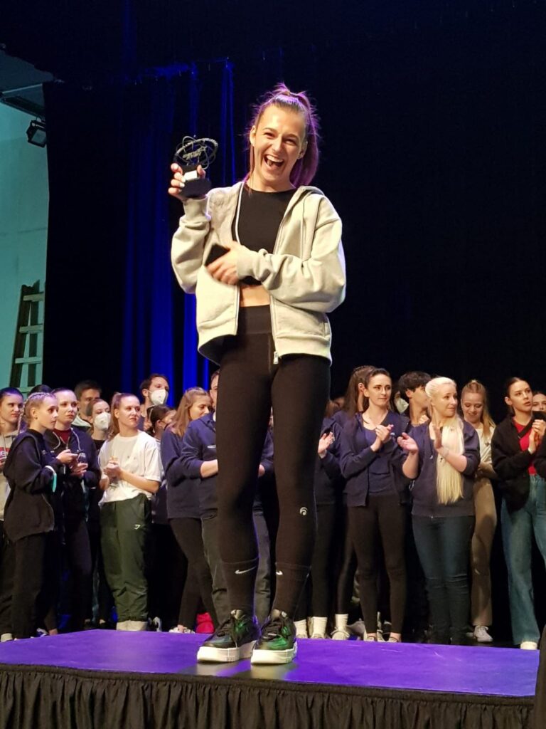 Nelly Elle Schmid lächelnd auf einem Podest mit einem Pokal in der Hand (privat)
